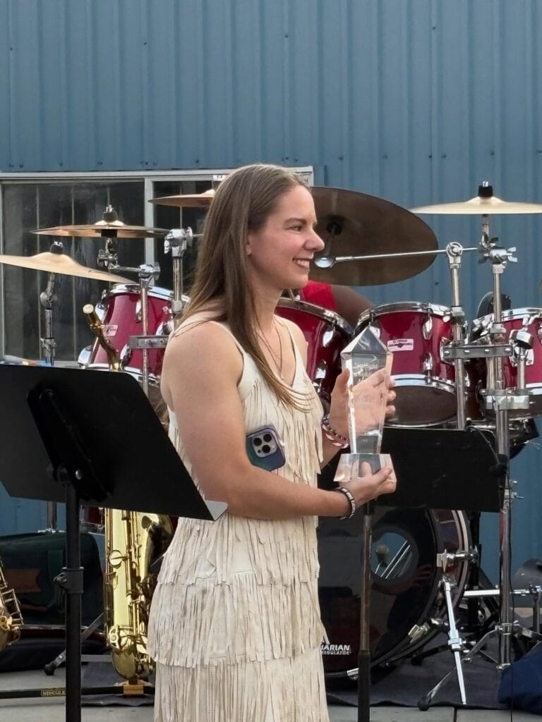 Kristy Janigo holding Bill's Wish "Spotlight a Solider" award.